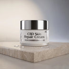 Jar of CBD Skin Repair Cream on a light surface with a neutral background