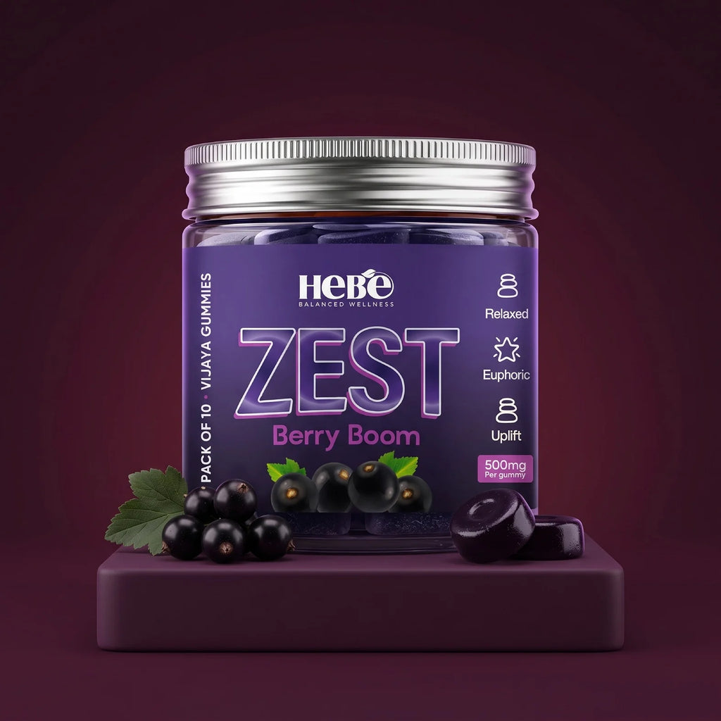 A jar of Hebe Zest Berry Boom 500mg gummies displayed on a matching purple pedestal. The product features a dark purple label with a silver metal lid, surrounded by fresh black berries and green leaves against a dark maroon background.